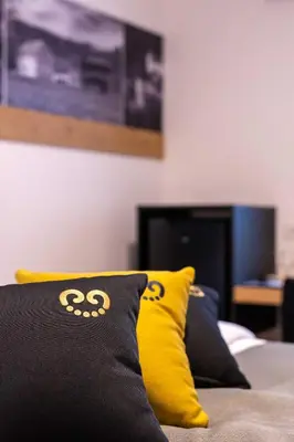 a yellow and black pillow sitting on a bed at Boutique Hotel Vila Loka in Škofja Loka