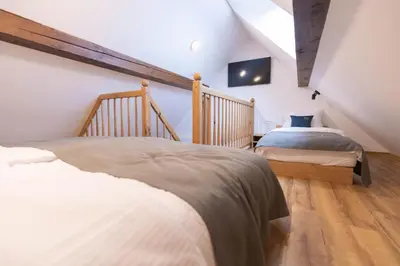 a attic bedroom with two beds and a tv at Boutique Hotel Vila Loka in Škofja Loka