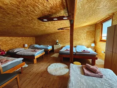 a bedroom with four beds in a room with a ceiling at Holiday Home Sveti Martin in Kobilje