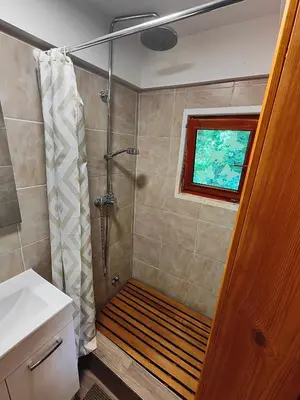 a bathroom with a shower with a bench in it at Holiday Home Sveti Martin in Kobilje