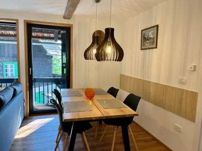 a dining room with a wooden table and chairs at Apartments Pri Fencu in Jesenice