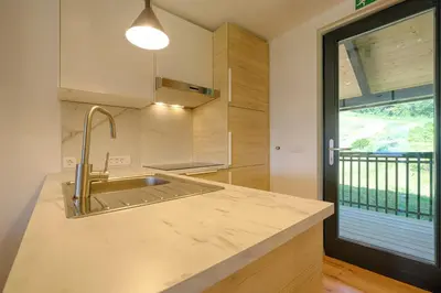 a kitchen with a sink and a large window at Apartments Pri Fencu in Jesenice