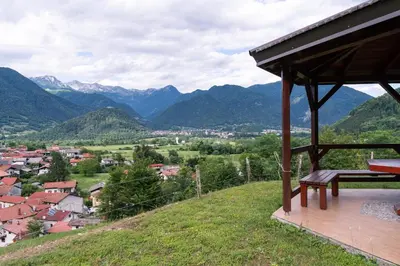 a bench sitting on top of a hill with mountains at Apartma pr' Gamilcu in Tolmin