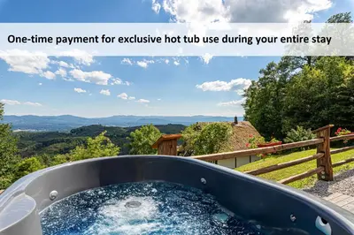 a jacuzzi tub with a view of the mountains at Glamping Paradise Škatlar in Otočec