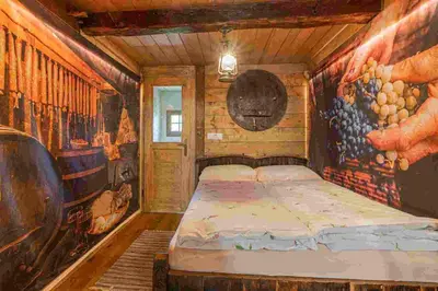 a bedroom with a bed in a room with paintings at Glamping Paradise Škatlar in Otočec