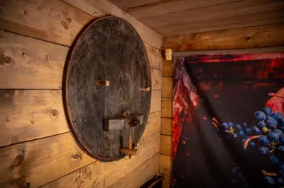 a wooden barrel on a wall with a painting at Glamping Paradise Škatlar in Otočec