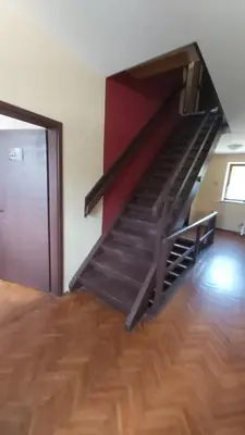 a staircase in a room with a wooden floor at Hostel in picerija Špajza in Mojstrana