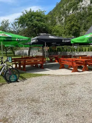 a group of picnic tables with umbrellas on them at Hostel in picerija Špajza in Mojstrana