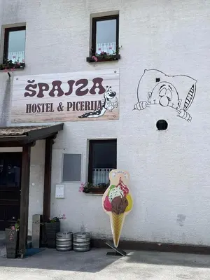 a building with an ice cream cone in front of it at Hostel in picerija Špajza in Mojstrana
