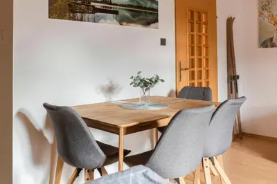 a dining room table with chairs and a vase of flowers at Apartma Alpine Space, Kranjska Gora - Center in Kranjska Gora