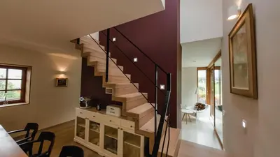 a staircase in a living room with a table and chairs at Old Taylor's house in Gradac