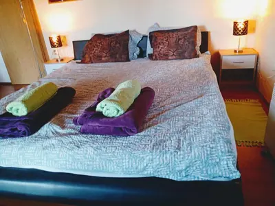 a large bed with pillows on top of it at Fairytale Wooden house by Ljubljana in Grosuplje