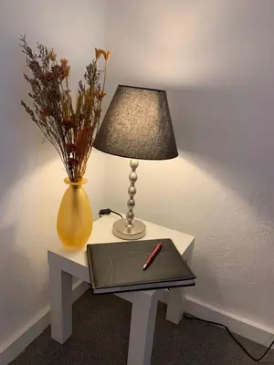 a table with a lamp and a notebook and a vase at Apartment Yiorgos in Bovec