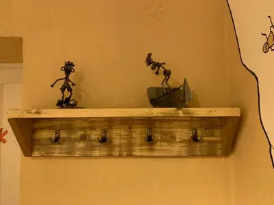 a wooden shelf on a wall with figurines on it at Apartment Yiorgos in Bovec
