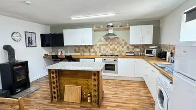 a kitchen with white cabinets and a wooden island at Hisa Luciano for 5 near Bovec in Bovec