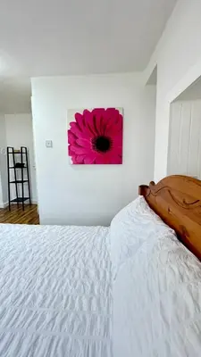 a bedroom with a white bed with a pink flower on the wall at Hisa Luciano for 5 near Bovec in Bovec