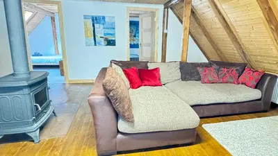 a living room with a couch and a stove at Hisa Luciano for 5 near Bovec in Bovec