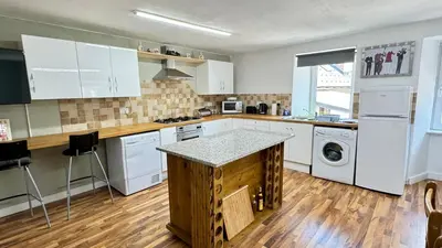 a kitchen with white cabinets and a counter top at Hisa Luciano for 5 near Bovec in Bovec