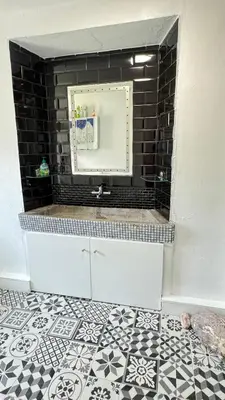 a bathroom with a mirror and a black and white tile floor at Hisa Luciano for 5 near Bovec in Bovec
