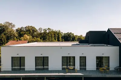 a white building with windows and a balcony at Postcard Country Apartments in Spodnji Duplek
