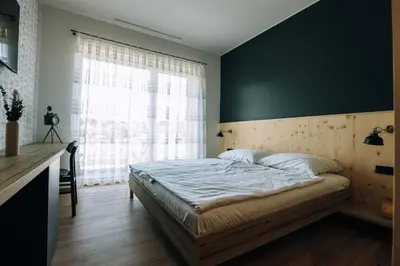 a bedroom with a large bed and a window at Postcard Country Apartments in Spodnji Duplek