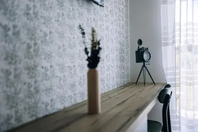 a vase of flowers sitting on a table with a camera at Postcard Country Apartments in Spodnji Duplek