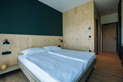 a bedroom with a large bed with a green wall at Postcard Country Apartments in Spodnji Duplek