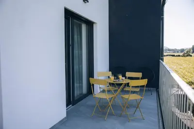 a table and chairs on the balcony of a house at Postcard Country Apartments in Spodnji Duplek