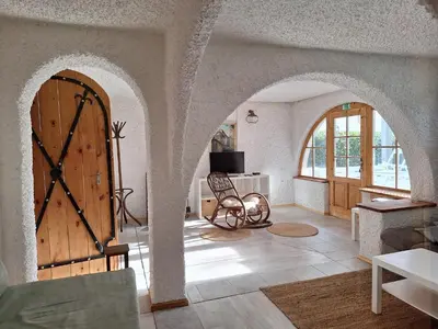 a living room with an archway and a wooden door at Hiša odprtih vrat in Tolmin