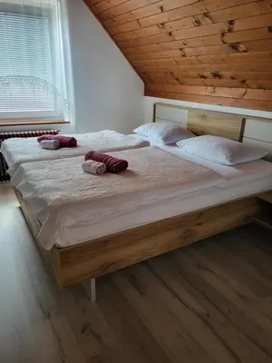 a bedroom with a large bed with two towels on it at Rooms MARETČ in Bohinj
