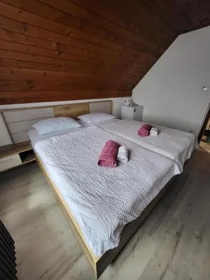 a large bed with two pink pillows on it at Rooms MARETČ in Bohinj