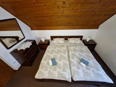 an attic bedroom with two beds and a mirror at Rooms MARETČ in Bohinj