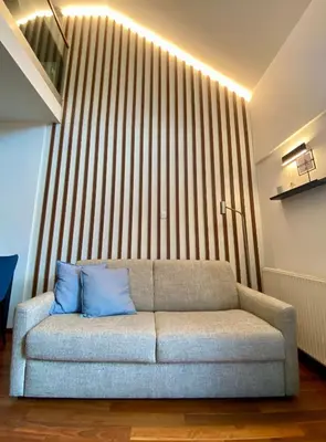 a couch with blue pillows in a living room at Olimian Retreat Rosa 421 in Podčetrtek