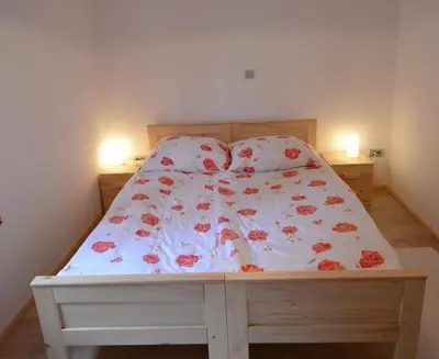 a bedroom with a bed with a floral bedspread at Apartments Mojca in Bled