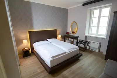 a bedroom with a white bed and a mirror at B&B Castanea in Kostanjevica na Krki