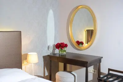 a bedroom with a mirror and a table with flowers at B&B Castanea in Kostanjevica na Krki