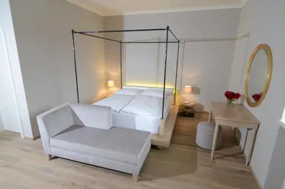 a bedroom with a bed and a chair and a mirror at B&B Castanea in Kostanjevica na Krki