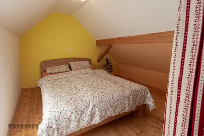 a bedroom with a bed and a yellow wall at Zidan'ca Rošel in Dolenjske Toplice