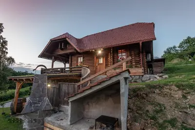 a log cabin with a staircase leading up to a house at Zidan'ca Rošel in Dolenjske Toplice