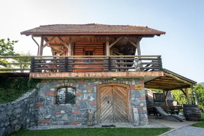 a log cabin with a porch and a wooden door at Zidan'ca Rošel in Dolenjske Toplice