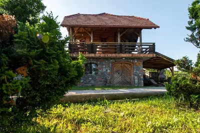 a log cabin with a porch and a wooden door at Zidan'ca Rošel in Dolenjske Toplice