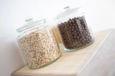 two glass jars filled with nuts and seeds on a shelf at Duplex Apartma Nikolina in Spodnje Jarše