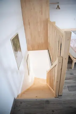a wooden staircase in a room with a bed at Duplex Apartma Nikolina in Spodnje Jarše