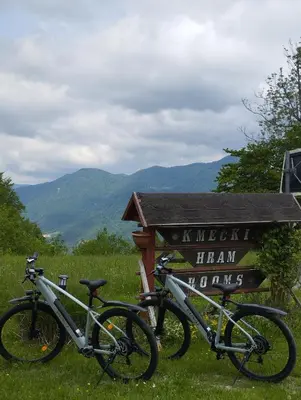 two bikes parked next to a sign in a field at Guest House Kmečki Hram FORTUNA in Idrija