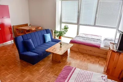 a living room with a blue couch and a table at Apartments and Studios Perunika in Moravske Toplice