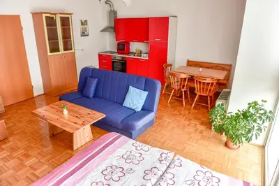 a living room with a blue couch and a table at Apartments and Studios Perunika in Moravske Toplice