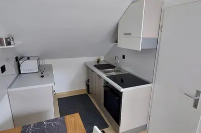 a small kitchen with white cabinets and a sink at JO-MA apartma - FREE parking in Ljubljana
