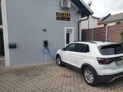 a white suv parked in front of a house at JO-MA apartma - FREE parking in Ljubljana