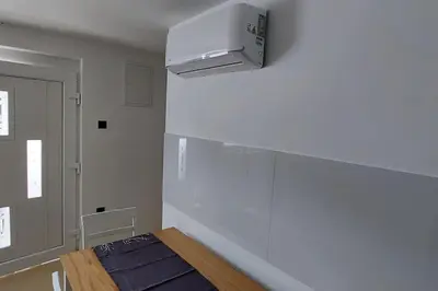 a kitchen with a stove and a white wall at JO-MA apartma - FREE parking in Ljubljana