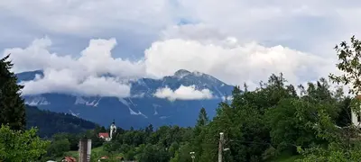 a mountain obscured by clouds with a town and a church at Apartma Bine in Bled